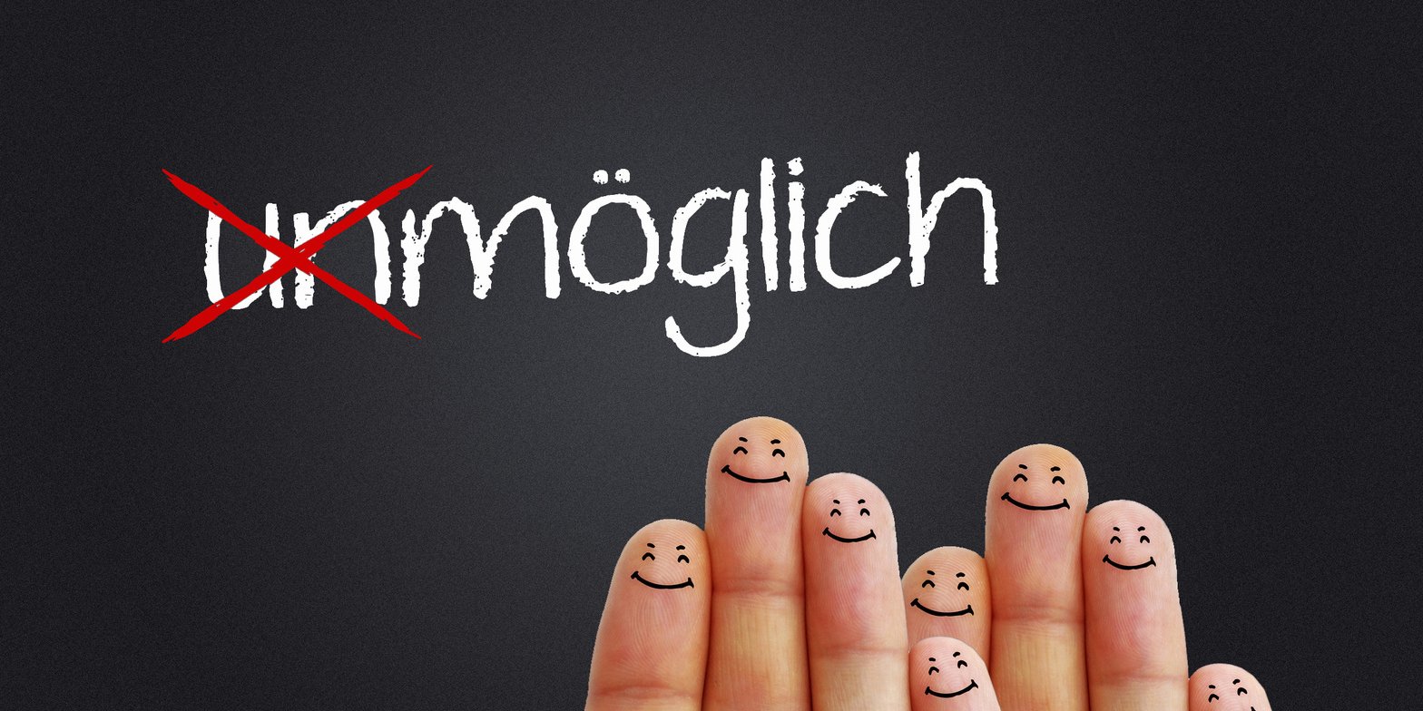 Bild - (un)möglich als Schriftzug und Finger mit Smileys darauf